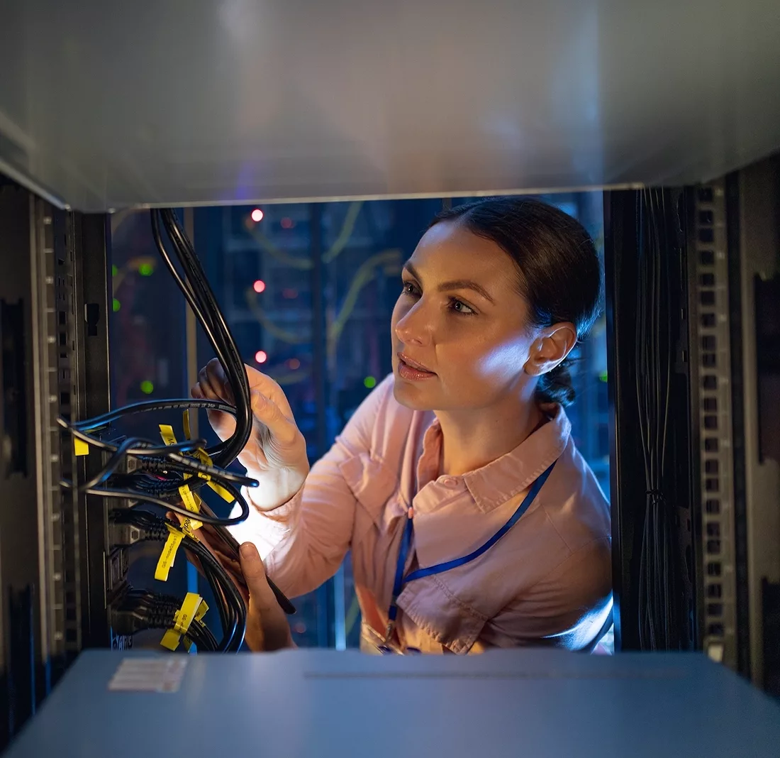 Caucasian female engineer inspecting the server in computer server room. database server management